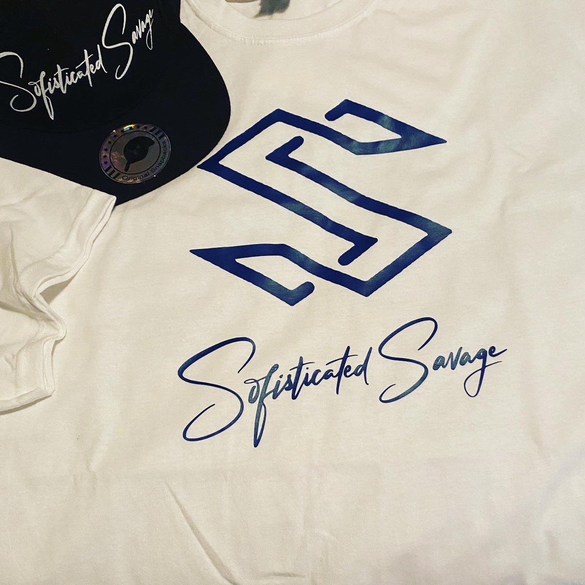 White Tshirt blue font of sophisticated Savage logo and font in script